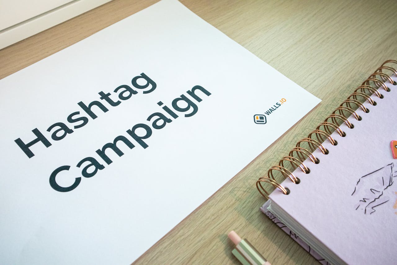 A clean office desk setup featuring hashtag campaign marketing materials and a planner.
